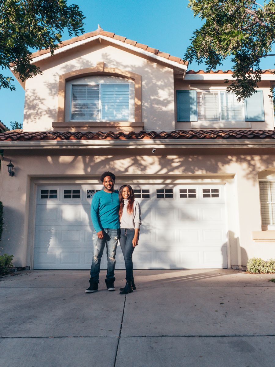 A couple in front of their home