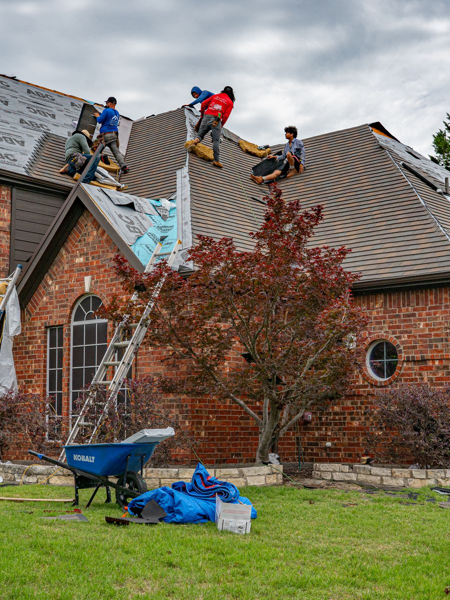 A roofing crew working under an overcast sky